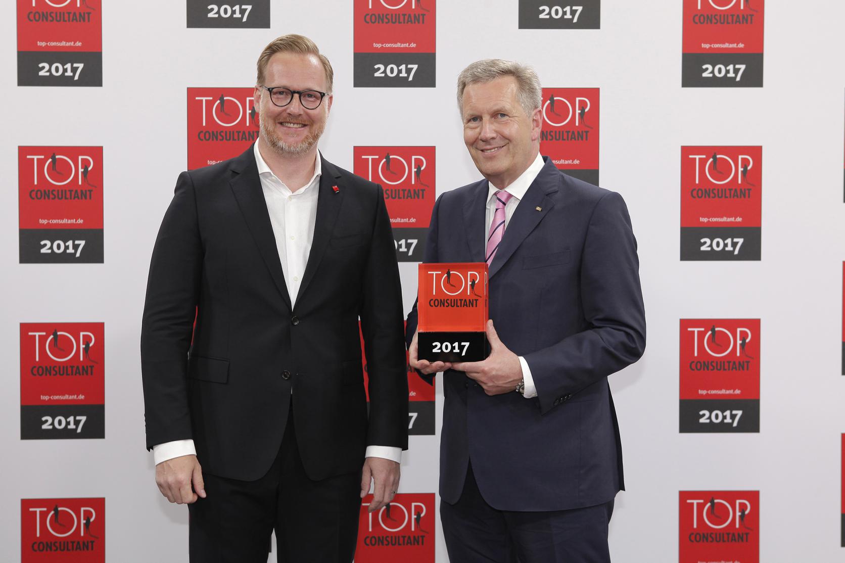 Oliver Hendy, Direktor bei Atreus, nimmt die Auszeichnung TOP Consultant 2017 von Christian Wulff entgegen